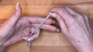 Lege den Faden vom Knäuel kommend von unten nach oben über den Mittelfinger und Zeigefinger der linken Hand.. Maschen Anschlagen