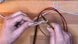 Lege die Schlaufe auf deine Nadel und ziehe mit dem Arbeitsfaden die Schlaufe zu. Maschen Anschlagen