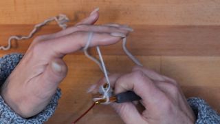 Führe den Arbeitsfaden zwischen Strick- und Häkelnadel nach hinten durch, sodass der Faden wieder hinter der Stricknadel liegt. maschen anschlagen