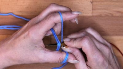 Nimm für die nächste Masche den Daumenfaden von oben nach unten. maschen anschlagen