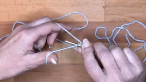 Führe die Nadel unter den Daumenfaden und hole den Faden vom Zeigefinger. Achte darauf, dass der Daumenfaden gespannt bleibt. Das ist die zweite Masche. . Maschen Anschlagen