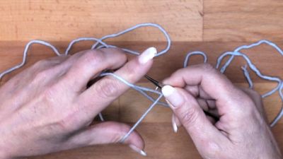 Führe die Nadel über den Faden vom Zeigefinger maschen anschlagen